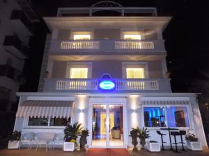 里米尼Hotel Residence Villa Del Mare的前面有蓝色标志的建筑
