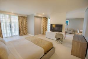 檀香山威基基海滩波利尼西亚酒店的一间卧室配有一张床和一台平面电视