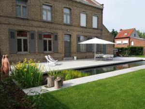 伊普尔De Pastorie - Zillebeke的一座带游泳池和遮阳伞的房子