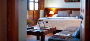 Alcalá de la Jovada拉丰特德尔卡拉旅馆的配有床和笔记本电脑桌的酒店客房