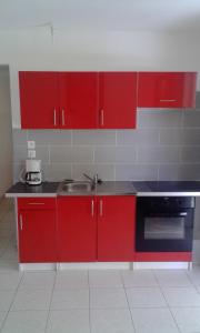 三河市villa telyna的一间带红色橱柜和水槽的厨房