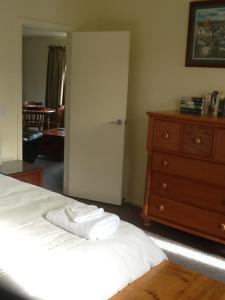 莫图伊卡River Terrace Cottage的一间卧室配有床和一个带毛巾的梳妆台。