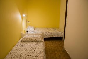 皮兰特拉公寓的配有黄色墙壁的小客房内的两张床