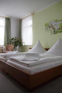 Thum图姆莱茨盖勒旅馆的一间卧室配有一张带白色床单的大床