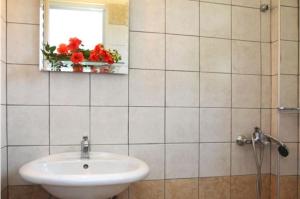 雷夫卡达镇埃莱安娜一室公寓酒店的一间带水槽和镜子的浴室以及窗户。