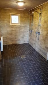 VelkuaSaaristohotelli Vaihela的带淋浴的浴室和瓷砖地板。