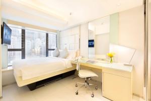 香港富荟上环酒店的一间卧室配有书桌、一张床、一张桌子和椅子