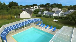 滨海皮里亚克VVF Piriac-sur-Mer Bretagne Sud的享有带椅子的游泳池和房屋的顶部景致