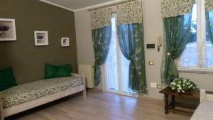 夸尔图-圣埃莱娜La Fontanella的一间卧室配有床和两个带窗帘的窗户