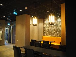 阿姆斯特丹Blossoms City Hotel的用餐室配有桌椅和吊灯。