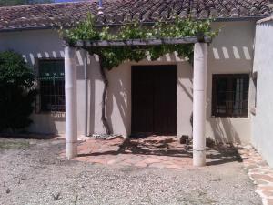 比利亚罗夫莱多Casa Rural La Navarra的一间白色的房子,有一道黑色的门和一些藤蔓