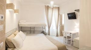 法萨诺Bed & Breakfast AMATI的白色卧室配有床、书桌和桌子