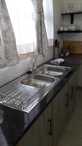 温特和克Self-catering Studio, Unit 6 on Krupp的厨房水槽旁设有碗碟干燥架