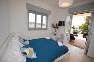 普尔萨诺Luxury Beach Villa Puglia Italy的一间卧室设有蓝色的床和一个阳台