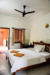 暹粒Jasmine Lodge Siem Reap的卧室配有一张白色大床和吊扇