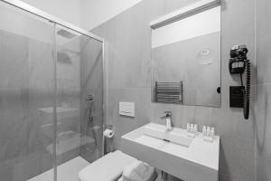 奥洛穆茨Theresian Hotel的一间带水槽、淋浴和镜子的浴室