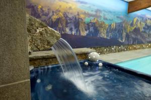 莫尔济讷Hotel L'Equipe的壁画前的带喷泉的热水浴池