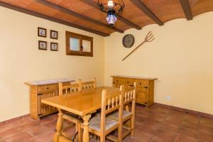 贝塞特Casa Las Eras的用餐室配有木桌和墙上的时钟
