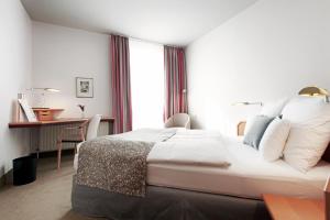 韦塞尔豪斯杜特恩酒店的酒店客房设有一张大床和一张书桌。