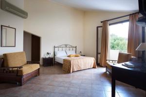 布塞托帕利佐洛Hotel Terra degli Elimi的卧室配有床、椅子和窗户。