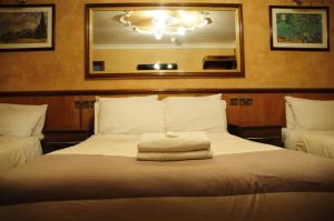 伦敦格力鲁乌德洛奇酒店的一间卧室配有一张床,床上有毛巾