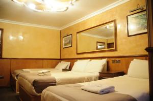 伦敦格力鲁乌德洛奇酒店的酒店客房,设有两张床和镜子