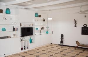 瓦加杜古Umoja Guesthouse II的客厅配有白色架子和平板电视