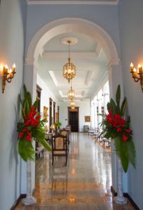 梅里达阿祖尔历史纪念碑酒店的一条带红色鲜花的走廊和用餐室