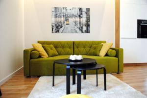 科沙林Apartament Zwycięstwa 98的客厅配有绿色沙发和桌子