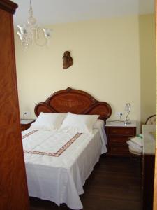 维拉加尔西亚·德·阿劳萨Apartamento Pedras的一间卧室配有一张大床和木制床头板