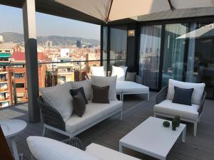 巴塞罗那桑特斯科斯莫公寓的大楼内的阳台配有沙发和桌子
