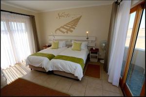 斯瓦科普蒙德Stay @ Swakop的卧室配有带绿色床单的大型白色床