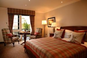 阿伯福伊尔Macdonald Forest Hills Hotel & Spa的酒店客房带一张床、一张桌子和椅子
