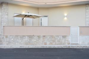 诺沃利B&B La Focara的一把太阳伞坐在建筑物的一侧