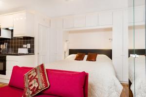亨利昂泰晤士Henley-on-Thames Studio Apartment的一间卧室配有一张床和一张红色的沙发