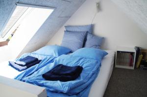 Malling奥胡斯湾的珍珠度假屋的一张带蓝色床单和枕头的床