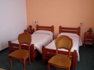 OnoreAlbergo Betulla的一间客房配有两张床和两把椅子