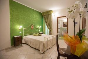 塔维亚诺B&B Le due gioie的一间卧室配有一张带绿色墙壁的床