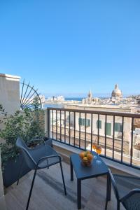 瓦莱塔La Falconeria Hotel的市景阳台配有桌椅。