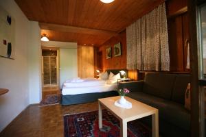 加舒恩萨拉蒂娜生态酒店的一间卧室配有一张床、一张沙发和一张桌子