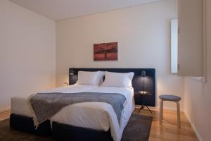 波尔图波尔图服务式公寓 - 阿尔瓦莱卡布拉尔的一间卧室配有一张带白色床单的大床