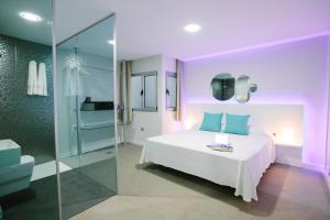 大加那利岛拉斯帕尔马斯Valentina Beach的卧室配有白色的床和玻璃淋浴间