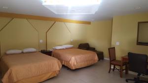 奥兰多经济型汽车旅馆的酒店客房,配有两张床和椅子