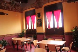AlvignanelloS.Maria degli Angeli C. Ospitalità的一间带桌椅和红色窗帘的餐厅