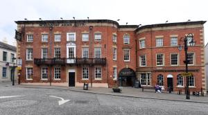 雷克瑟姆Wynnstay Arms, Wrexham by Marston's Inns的城市街道上一座大型红砖建筑