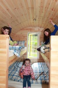 CampCoach Field Camp的两个女孩和一个小女孩坐在双层床里