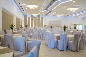 佩奇King Hotel的宴会厅配有白色的桌子和白色的椅子