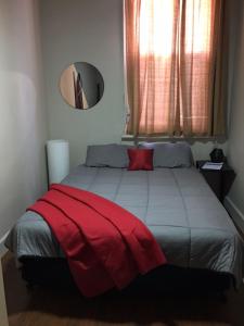 德尼利昆爱德华河酒店的一间卧室配有一张床铺,床上铺有红色毯子
