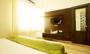 哈里瓦Vibhav Grand的一间卧室配有一张床和一台电视