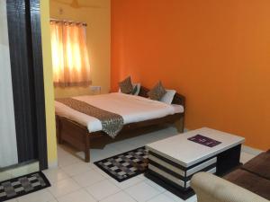 兰奇Hotel Arham Inn的一间卧室配有一张橙色墙壁的床